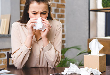 Woman suffering from horrible alergies at work