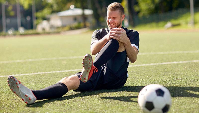 Soccer player suffering with sports injury