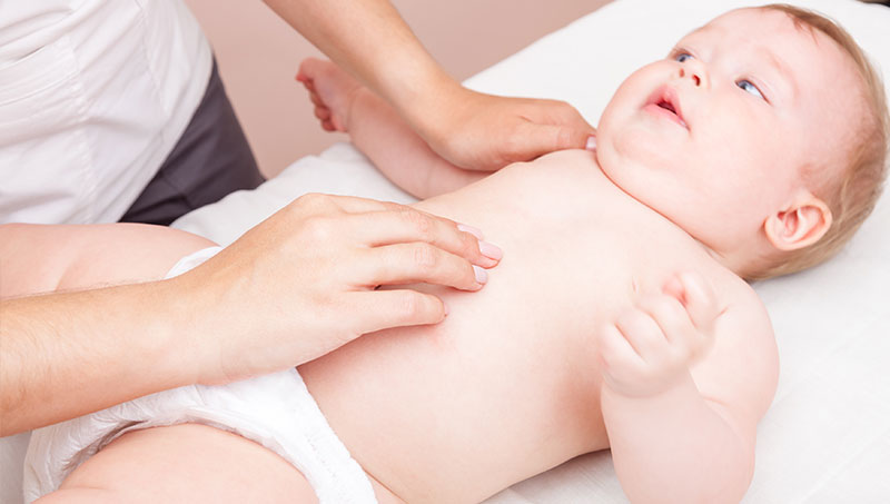 Baby being treated for colic with chiropractic care